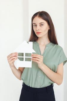 家の切り抜きを持つ女性スタッフ 保険業,事務職,接客業の写真素材