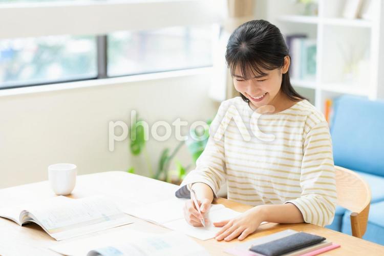 リビングで勉強をする大学生の女性 教育,勉強,女性の写真素材