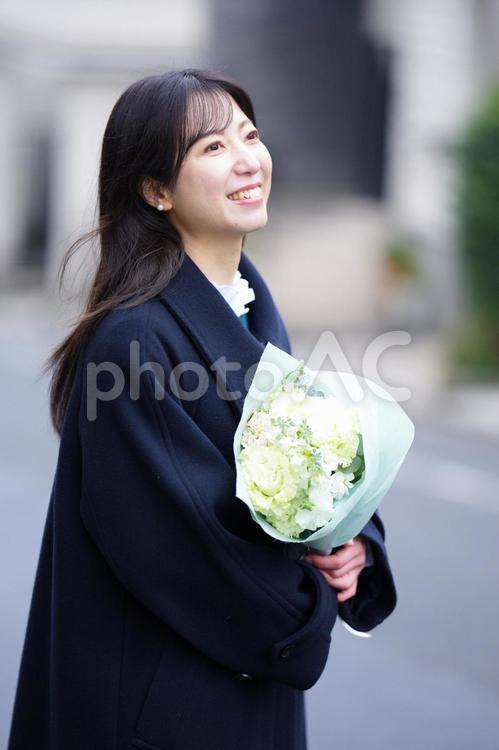 笑顔で花束を持っている女性 女性,人物,ロングヘアの写真素材