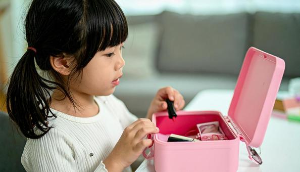 子供用のメイクボックスとメイクする女の子の写真