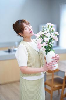 目を瞑り花びんを持つ女性 女性,花,花瓶の写真素材