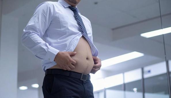 メタボリックなお腹に手を触れる男性 メタボリックなお腹に手を触れる男性の写真
