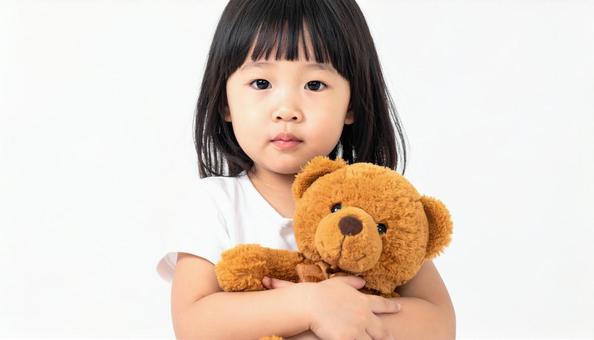 お気に入りのクマのぬいぐるみを抱く子供の写真
