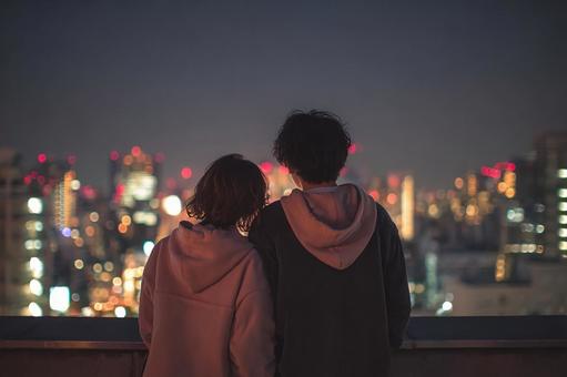 都会の夜景を楽しむカップル 都会の夜景を楽しむカップルの写真