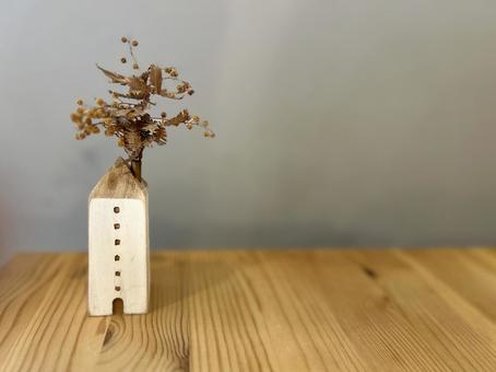 ドライフラワーと壁と机の写真