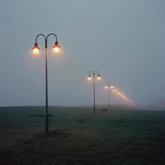 霧の中に並ぶ複数の街灯 霧の中に並ぶ複数の街灯の写真