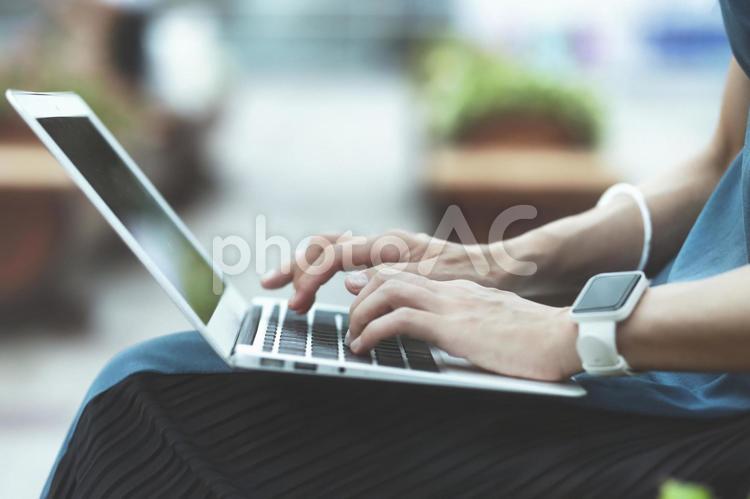屋外でラップトップを使用する人物の手元クローズアップ 背景ぼかし パソコン,ラップトップ,ノートパソコンの写真素材