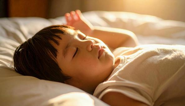 手をあげて熟睡する男の子 手をあげて熟睡する男の子の写真