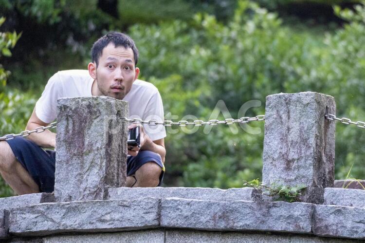 石橋の上からこちらを眺める男性 男性,日本人,緑の写真素材