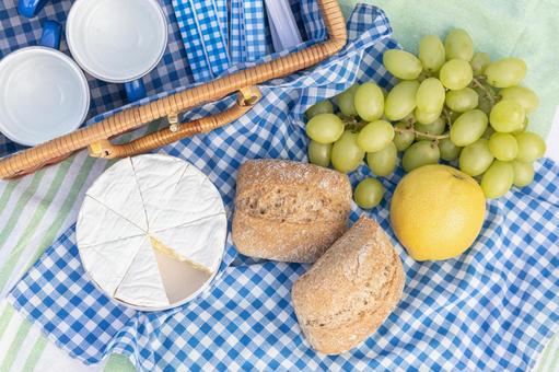 青い布の上に置かれたフルーツやパン ピクニックバスケット,パン,ランチの写真素材