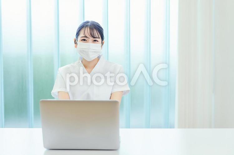 マスクをしてパソコンを使う白衣姿の女性 看護師,医療事務,ナースの写真素材