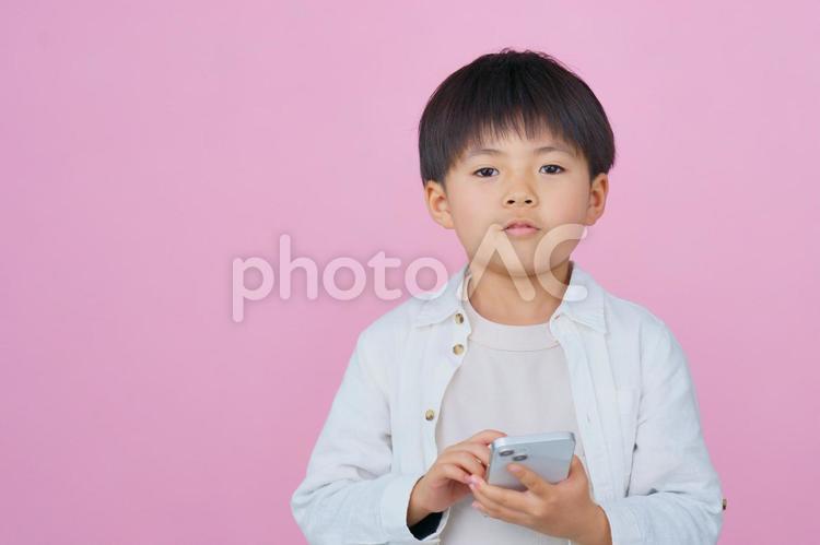 スマートフォンを持つ男の子 男の子,男児,カメラ目線の写真素材
