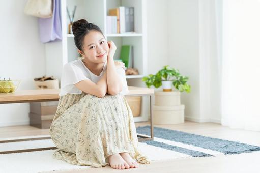 リビングでくつろぐ若い女性 リビングでくつろぐ若い女性 女性,笑顔,家の写真素材