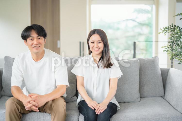 ソファでくつろぐ男女（カメラ目線） 夫婦,カップル,家族の写真素材