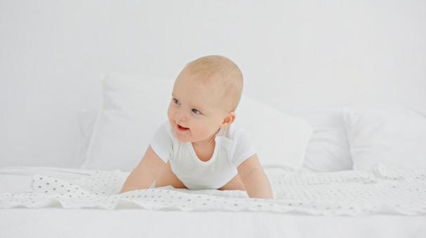 ハイハイのポーズで振り向き笑う赤ちゃん ハイハイのポーズで振り向き笑う赤ちゃんの写真