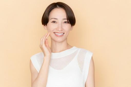 スキンケアをするミドルの女性 スキンケアをするミドルの女性の写真