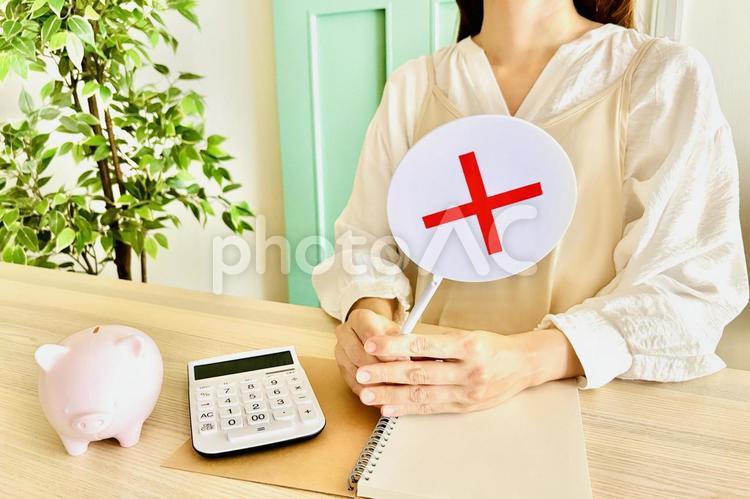 エプロン姿の女性と家計のNGのイメージ 主婦,家計,バツの写真素材