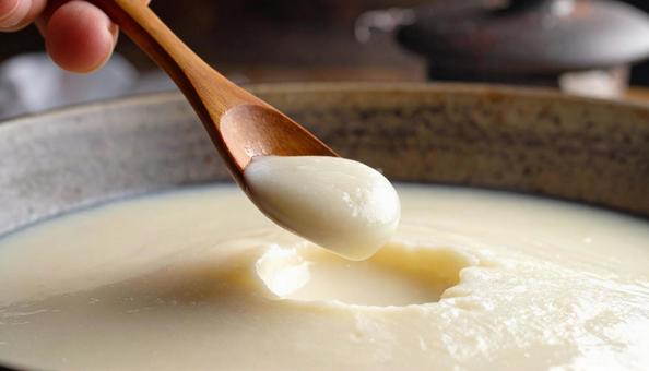 甘酒を木のスプーンで掬うの写真