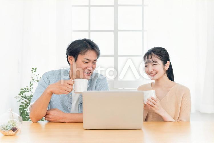 ノートパソコンを見る夫婦（笑顔） パソコン,光テレビ,動画の写真素材