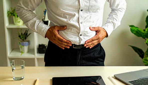 メタボリックなお腹に手を触れる男性 メタボリックなお腹に手を触れる男性の写真