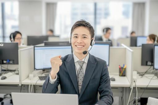 ガッツポーズするコールセンタースタッフ ガッツポーズするコールセンタースタッフ 男性,若手社員,ビジネスマンの写真素材