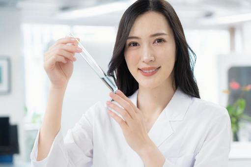 実験をする白衣の若い女性研究者 実験をする白衣の若い女性研究者 研究,サイエンス,実験の写真素材