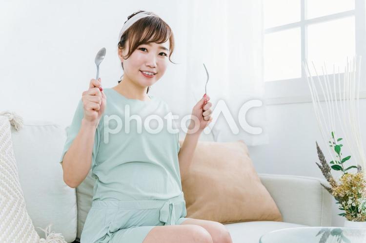 スプーンとフォークを持つ日本人の妊婦 妊婦,肥満,大食いの写真素材