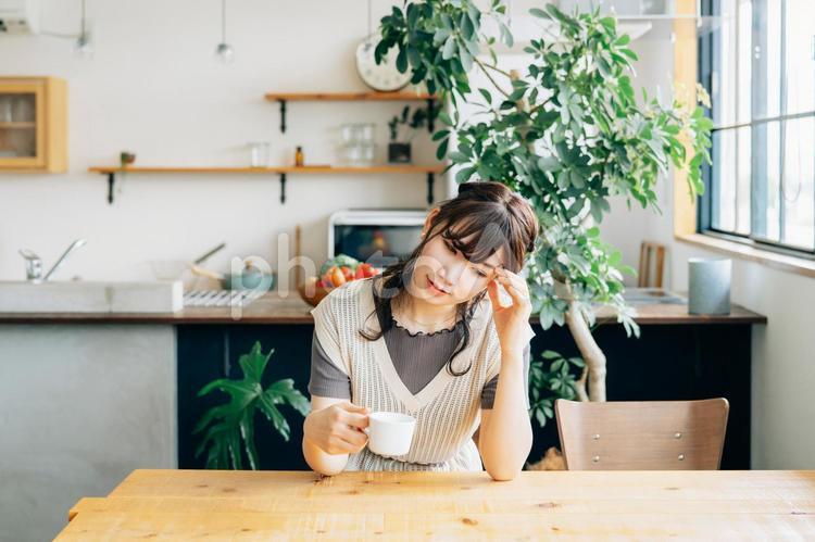 コーヒーを飲む女性（悩む） 頭痛,悩む,困るの写真素材