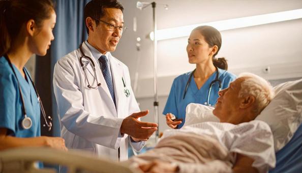 入院患者と家族に説明をする男性医師 入院患者と家族に説明をする男性医師の写真