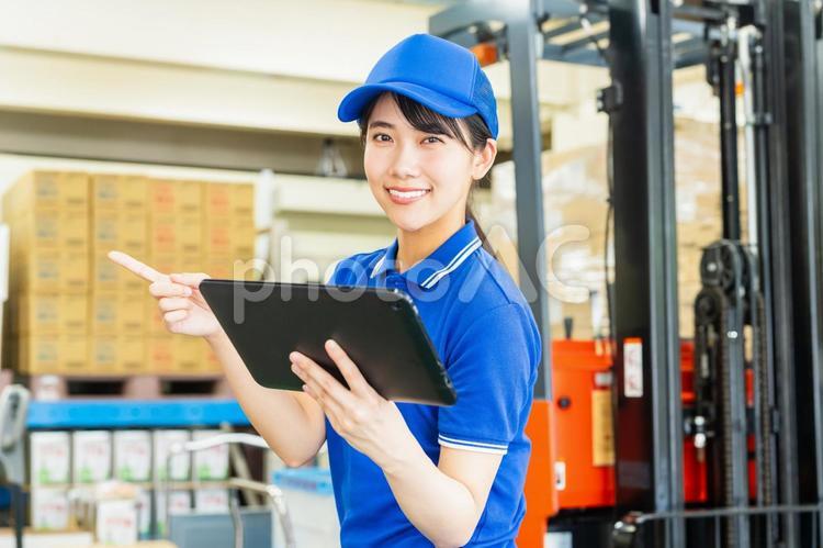 荷物を管理する若い女性 倉庫,工場,笑顔の写真素材