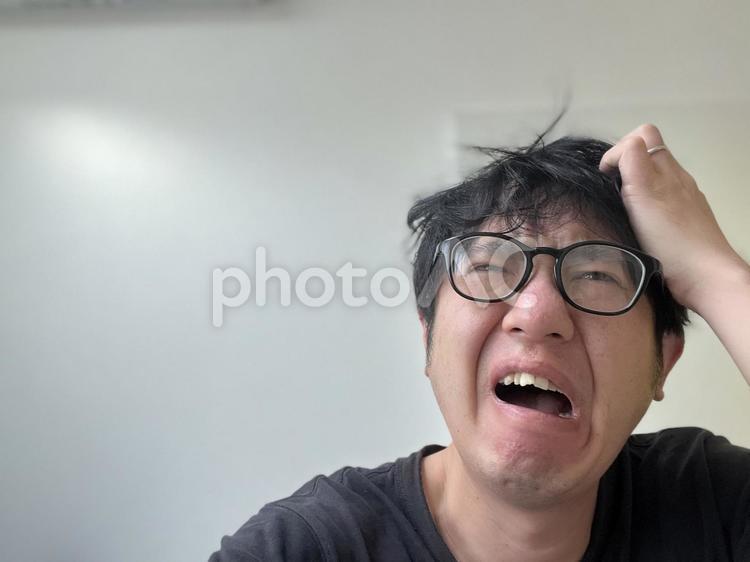 慌てるメガネの男性　 慌てる,寝坊,ハプニングの写真素材