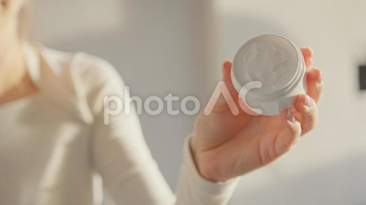 クリームジャーを見せる女性の上半身 女性,外国人,1人の写真素材
