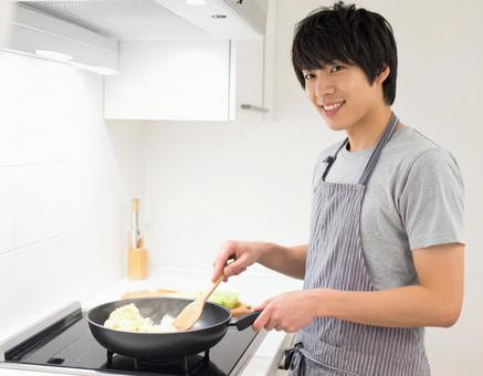 キッチンで料理をする男性 キッチンで料理をする男性の写真