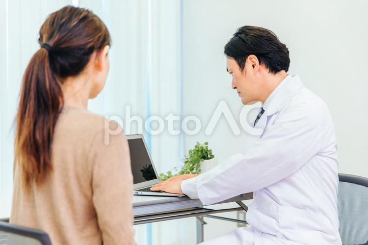 診察する男性医師と女性患者（ノートパソコン） 人間ドック,健康診断,婦人科検診の写真素材