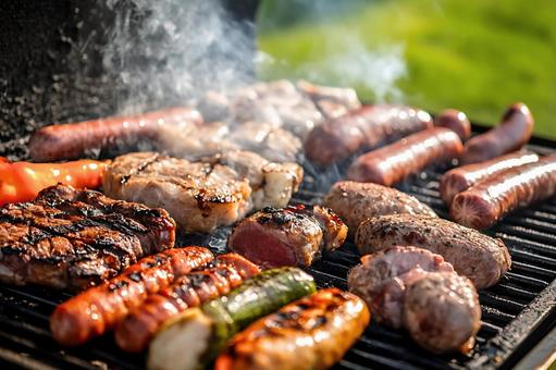 炭火で焼かれる肉と野菜のバーベキューの写真