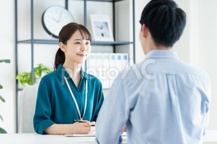 若い男性の受付をするプランナーの女性 受付,営業,相談の写真素材
