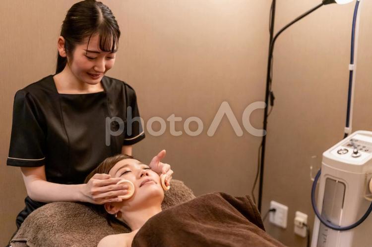エステサロンで施術を受ける女性（拭き取り） フェイシャルエステ,エステサロン,スキンケアの写真素材