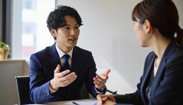 テーブルを囲んで会議するビジネスパーソンの写真