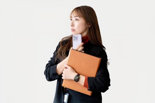 スマホとバインダーを持つ女性 スマホとバインダーを持つ女性 女性,スマホ,スマートフォンの写真素材