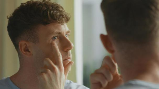 洗面所の鏡で目元をチェックする男性 男性,外国人,欧米人の写真素材