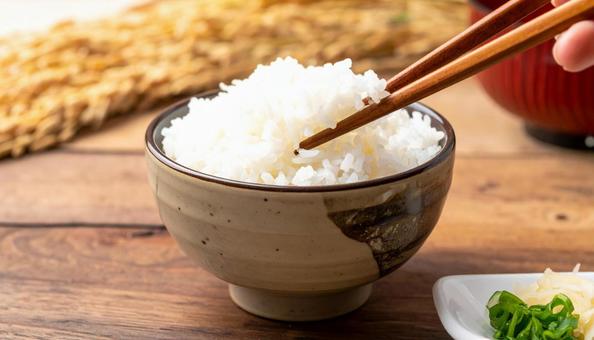 茶碗に盛り付けたご飯を箸でとる 茶碗に盛り付けたご飯を箸でとるの写真