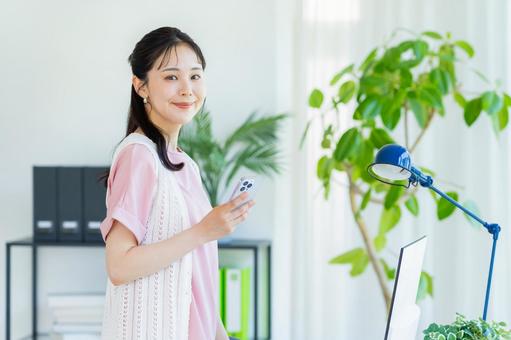 スマホを操作する若い女性 スマホを操作する若い女性の写真
