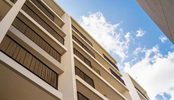 マンションを見上げる 青空背景 マンションを見上げる 青空背景の写真