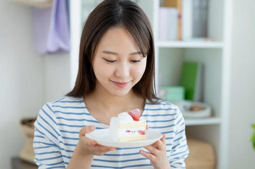 ケーキを食べる若い女性 ケーキを食べる若い女性 ケーキ,女性,スイーツの写真素材