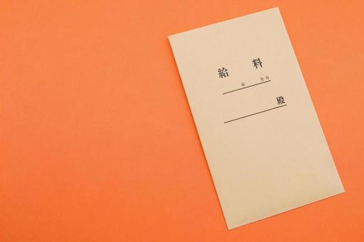 ビビッドなオレンジ背景に置かれた給料袋 給料袋,給料,お金の写真素材