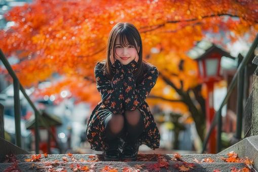 紅葉を背景に座る女性 紅葉を背景に座る女性の写真