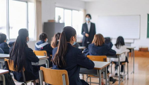 授業中の中学生の女子生徒の写真