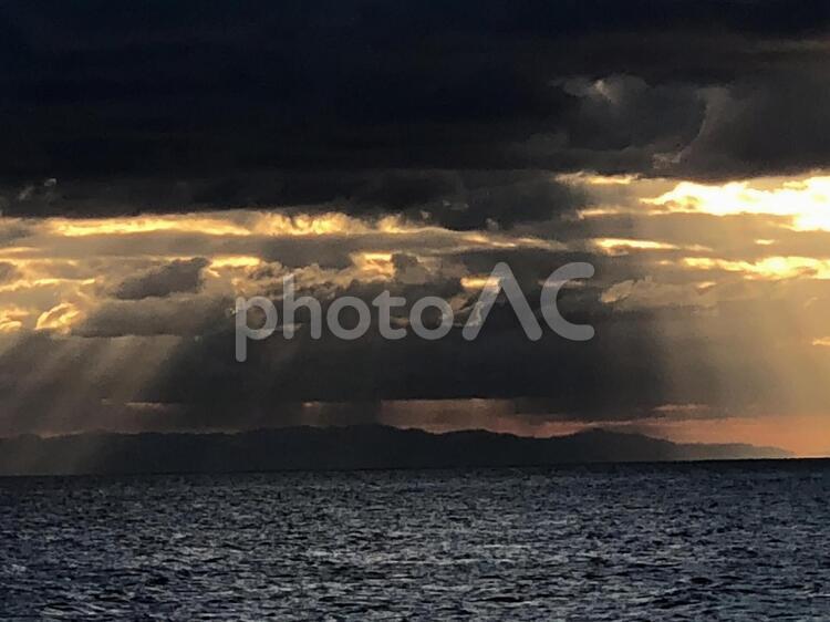 雲の隙間から覗く夕日 日暮れ,水域,暴風の写真素材