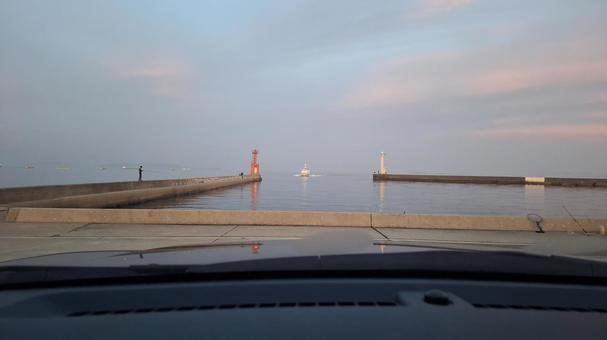 車の中から 海,灯台,堤防の写真素材