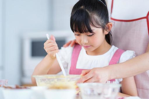 ボウルの中身を混ぜる女の子 女の子,小学生,日本人の写真素材